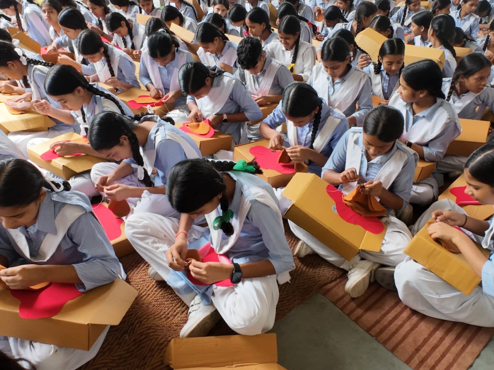 Schoolgirls stitching their own reusable cloth pads during a FlowLab workshop